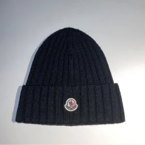 Äkta Moncler mössa - Tja! Säljer nu min moncler mössa eftersom jag är i behov av pengar.9/10 i skick.Inga byten