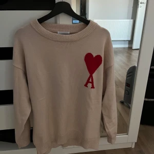 Beige stickad tröja från Ami Paris med rött hjärta  - Säljer en beige stickad tröja från Ami Paris. Storlek M 
