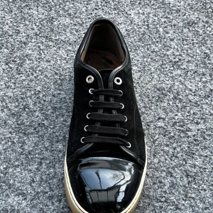 Svarta sneakers från Lanvin stl 46  - Säljer nu mina lanvins då jag ej använder dom längre. Dom är använda i 2 år. Men är fortfarande i bra skick. Vanligt slitage och lite gulare ton på sulan, men dessa problem går att fixa till enkelt med lite skofärg. Box och dustbags medföljer självklart. Vid fler frågor så är det bara att kontakta mig via annonsen. 