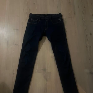 Mörkblå Replay Anbass jeans - Säljer ett par mörkblå Replay Anbass jeans med klassisk femficksdesign och snygga kontrastsömmar. Modellen har normal passform och raka ben. Perfekta för dig som gillar stilrena och bekväma jeans. Storlek W34 L32. Passar väldigt bra för grisch stilen. 