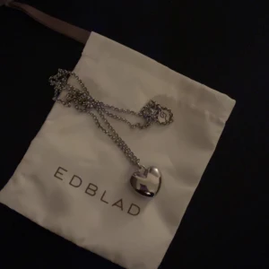 Halsband med hjärta Edblad - Jättefint halsband från Edblad med ett silverfärgat hjärta som hänge. Perfekt för att ge en extra touch till din outfit. Kommer med en fin kedja. används en gång
