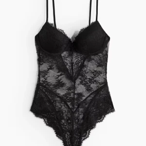Svart spetsbody med tunna axelband - Säljer en svart body i genombruten spets med tunna axelband och vadderade kupor. Bodyn har vacker spetsdetalj över hela plagget och en feminin, figurnära passform. Perfekt för att känna sig extra snygg.      Skriv för flera bilder💗 