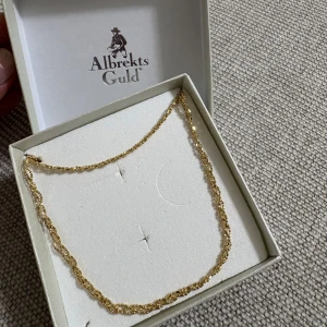 Halsband och armband från Albrekts Guld - Säljer ett matchande set med halsband och armband från Albrekts Guld. Kedjorna har ett tvinnat mönster som ger en elegant look. Perfekt för dig som gillar klassiska smycken i guld. Aldrig använd. De är guld pläterade och rostfria. 