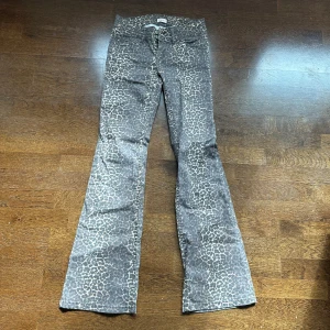 Bootcut leopardmönstrade byxor från Nelly - Säljer ett par bootcut byxor från Nelly med snyggt leopardmönster i grå och beige toner. Byxorna har låg midja och utställda ben, perfekta för dig som vill sticka ut med din stil. Använd ca 3 ggr så mycket bra skick!