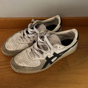 Onitsuka Tiger sneakers - Säljer ett par klassiska vita Onitsuka Tiger sneakers med svarta ränder på sidorna. Snörena är inte original och låda medföljer ej. 