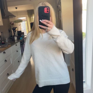 Vit stickad tröja - Mysig vit stickad tröja med rund halsringning och långa ärmar. Tröjan har en enkel och klassisk design med ribbade muddar vid ärmslut och nederkant. Är i XS men är både stor i storlek och stretchig, så passar XS-M.Skriv innan köp 🥰❤️