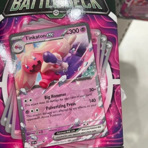 Pokémon Battle Deck med Tinkaton ex - Säljer en Pokémon Battle Deck med Tinkaton ex som huvudkort. Innehåller en färdigbyggd 60-kortslek med starka attacker som Big Hammer och Pulverizing Press. Perfekt för både samlare och spelare som vill dominera i strid. Inkluderar även referenskort, regelbok och en stor metallisk mynt.
