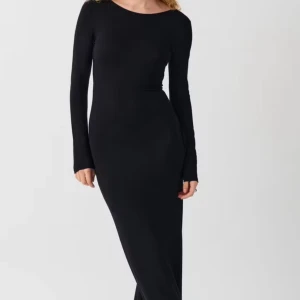 Svart långklänning med öppen rygg - Elegant svart långklänning med en stilren design och en dramatisk öppen rygg. Klänningen har långa ärmar och en figurnära passform som framhäver silhuetten. Perfekt för en kväll ute eller en speciell tillställning.