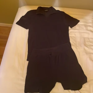 Svarta shorts från Race Marine - Svarta shorts från Race Marine med elastisk midja och snörning. Klassisk och enkel design i mjukt material, perfekta för sommardagar eller träning. Matchar lätt med olika överdelar.