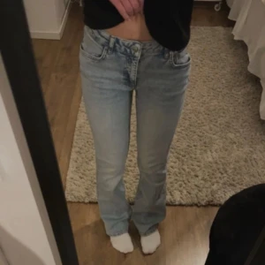 Ljusblå jeansbyxor från Gina Tricot - Säljer ett par ljusblå jeans från Gina Tricot med klassisk femficksdesign och raka ben. Jeansen har normal passform och är perfekta för en avslappnad stil. De har en enkel look utan slitningar eller dekorationer.