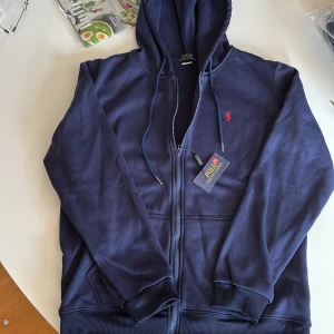 Ralph Lauren zip - Säljer en mörkblå hoodie från Polo Ralph Lauren med dragkedja och huva. Endast testad på men passa ej, 10/10 kvalité. Kom med bud🌟🤩