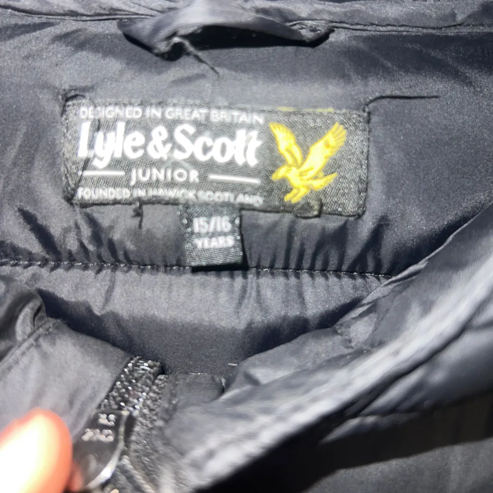 Säljer min svarta vårjacka från Lyle & Scott med huva och dragkedja framtill. . Takit.