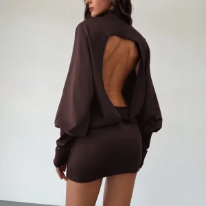 Klänning - Snygg brun klänning med lång ärm och en stilren öppen rygg. Perfekt för en kväll ute eller en speciell tillställning. Den korta längden ger en modern look.