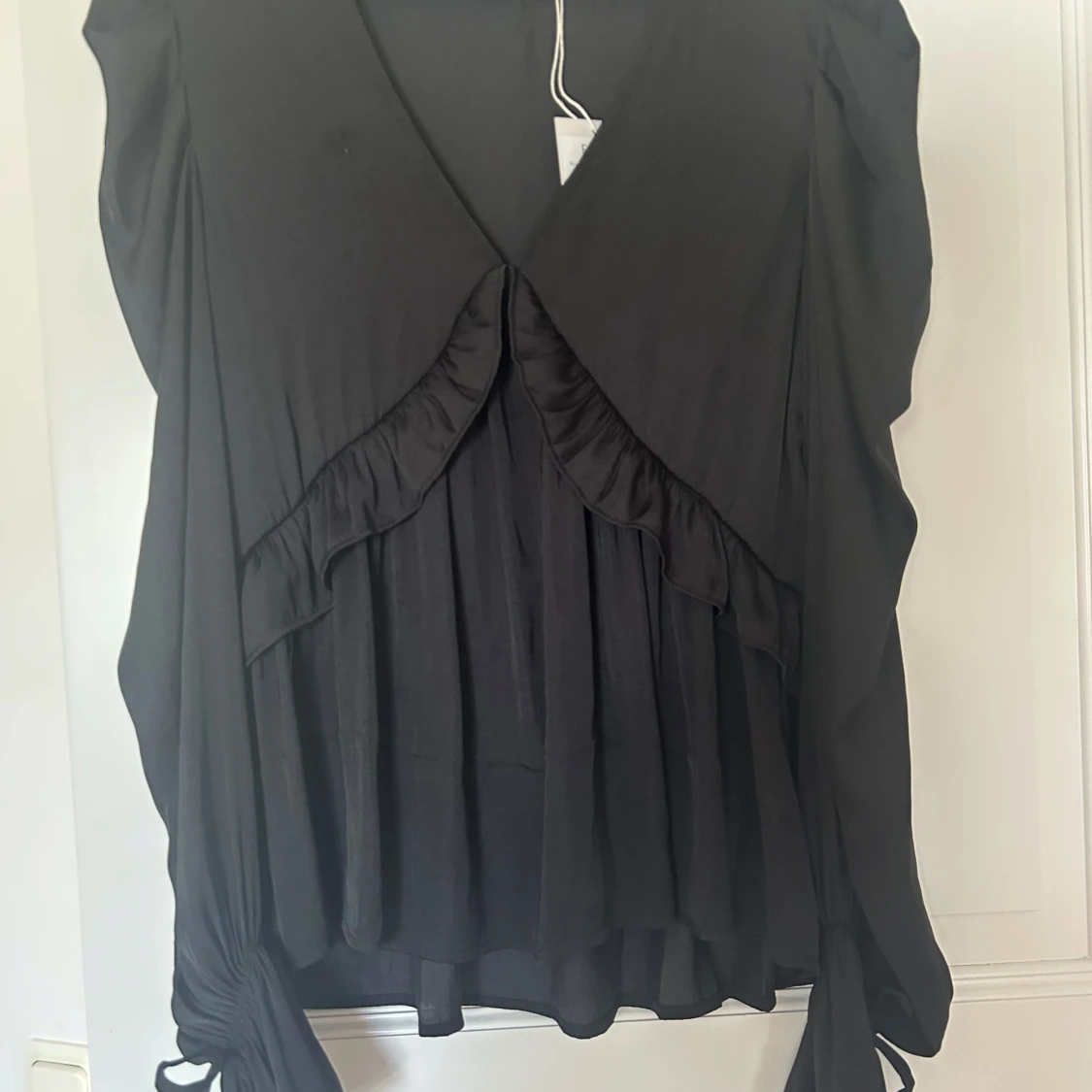 Svart blus med volang och v-ringning - 1