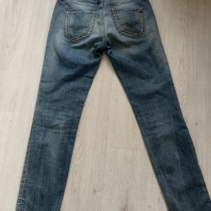 Replay Rakis jeans i ljusblå - Säljer ett par Replay Rakis jeans i klassisk ljusblå med raka ben och femficksdesign. Jeansen har normal passform och är tillverkade i slitstarkt denim. Perfekta för dig som gillar en tidlös stil med snygga detaljer.