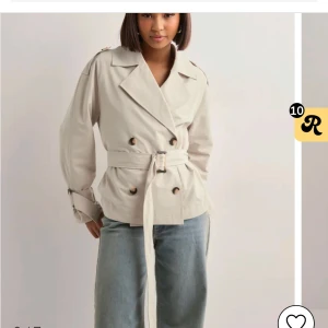 Beige trenchcoat med bälte - Säljer denna slutsålda trenchcoat från Nelly. Jätte fin och perfekt till vår och sommar, storlek xs men passar s också