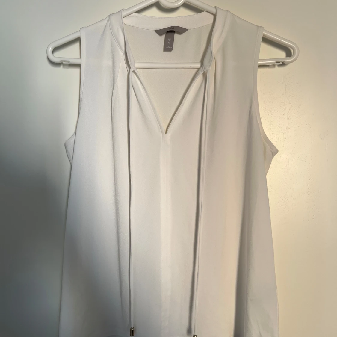 Vit ärmlös blus med knyt från H&M