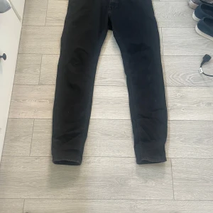 Svarta stretchjeans från Hugo Boss - Säljer ett par svarta stretchjeans från Hugo Boss. Byxorna har klassisk femficksdesign och smal passform. Perfekta för dig som vill ha ett stilrent och bekvämt plagg i garderoben.