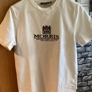 Vit t-shirt från Morris - Vit t-shirt från Morris Sporting Club med broderad logga och text på bröstet.  Storlek Xs. Otroligt fint skick 