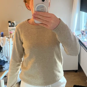 Beige stickad tröja från VILA - Säljer en klassisk beige stickad tröja från VILA. Tröjan har rund halsringning, långa ärmar och ribbade muddar vid ärmslut och nederkant. Perfekt basplagg i garderoben och supermjuk mot huden. Hör av er vid fler frågor eller bilder.💛
