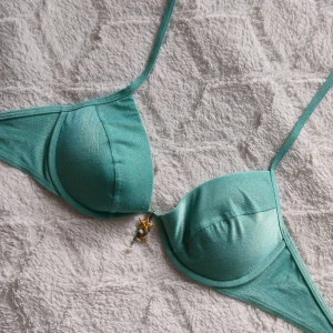 Turkos push up bikiniöverdel med gulddetalj💞 - Hej, Säljer en jätte vacker turkos 🩵bikiniöverdel från Victoria´s Secret med vadderade kupor som går att ta bort! Materialet är mjukt med glittrig touch och har fina gulddetaljer. Insidan är beige. Bikinin är knappt använd och har inga skråmor. Säljer då den tyvärr inte passar🥲❤️