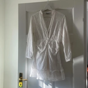 Säljer en vit jättefin mini spetsklänning från Zara🤍 - Jättesnygg mini vit klänning från Zara i storlek S med spetsdetaljer och knappar framtill. Den är bara andvänd några gånger och är perfekt till våren/sommaren🩷Den är jättegullig till studenten, balen, skolavslutningen och andra speciella tillställningar🌸Den är ganska kort, jätte skön, är i bra kvalité/material, har jättefin passform och är enkel att styla⭐️Klänningen har långa ärmar och en volangkant nedtill. Perfekt för sommarens alla tillfällen! 🌸skriv om funderingar och priset kan diskuteras😊