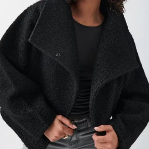 Svart teddyjacka med oversized krage - Säljer en svart teddyjacka med stor, bred krage och oversized passform. Jackan har lång ärm och stängs med knapp framtill. Perfekt för dig som gillar en trendig och mysig look.