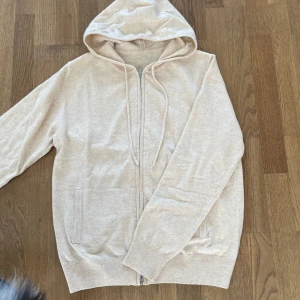Kashmir/Merinoull Zip Hoodie - En riktigt stilren Kashmir/Merinoull Zip Hoodie i storlek S!🌟 Perfekt tröja inför sommaren! Riktigt snygg beige färg! Bara testad, aldrig använd! Hör av dig vid intresse eller minsta fundering😊