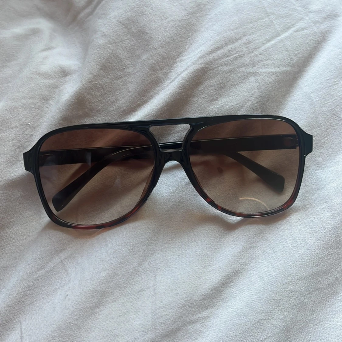 Svarta solglasögon med bruna linser