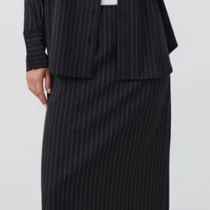 Svart långkjol med  skjorta vita ränder - Säljer en svart långkjol med tunna vita ränder. Kjolen har en klassisk rak passform och är perfekt för dig som gillar en stilren och tidlös look. Passar lika bra till skjortan som till en enkel topp.