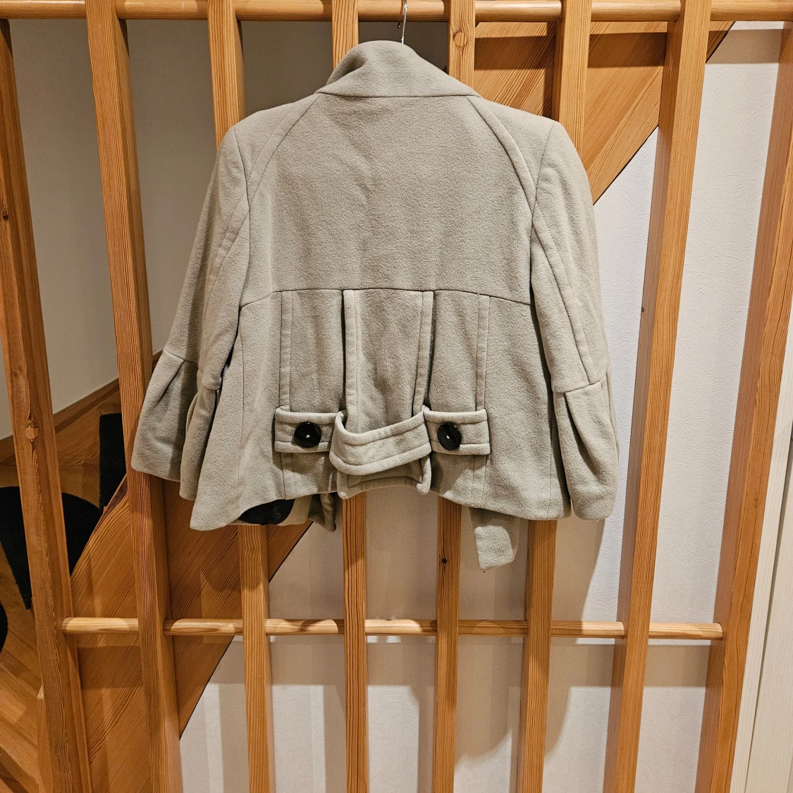 Ljusgrå kappa med knappar och volangärm