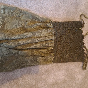 Olivgrön spetstopp med smock och axelband - Supersöt olivgrön topp med smock upptill och tunna axelband. Kjolen är täckt av ett vackert blommigt spetslager som ger en romantisk känsla. Perfekt för sommarens alla tillfällen!🩵🩵