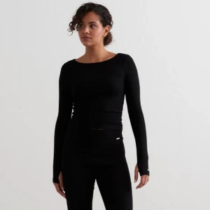 Svart ribbad långärmad topp - Säljer en svart, tight och ribbad långärmad topp med rund halsringning. Perfekt basplagg som sitter snyggt och har en stilren look. Ärmarna har en liten detalj med öppning vid handleden. Oanvänd💕