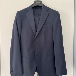 Mörkblå kostym från Oscar Jacobson - Säljer en klassisk mörkblå kostym från Oscar Jacobson. Använts ett fåtal gånger och är i mycket bra skick! 