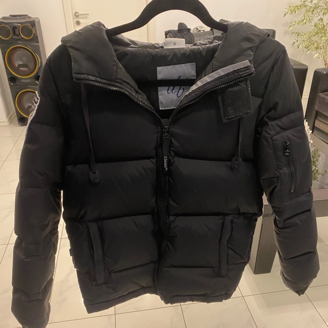 Svart pufferjacka med huva och patch