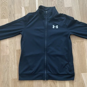 Under Armour zip up hoodie - Svart Under Armour zip hoodie i svart ganska ny använt några gånger