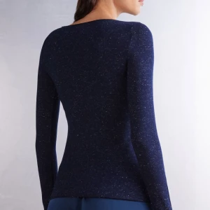 Mörkblå långärmad topp från intimissimi - Säljer en mörkblå långärmad topp från intimissimi. Tröjan är figurnära med diskret melerat mönster och rund halsringning. Tillverkad i mjukt och stretchigt material som sitter skönt mot kroppen.💕