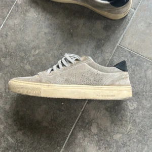 Beige sneakers från P448 i mocka - Säljer ett par beige sneakers från P448 i mocka med vit sula och svarta detaljer vid hälen i storlek 41 men passar även 42. Skorna har snörning och rund tå, samt diskreta perforeringar på sidorna. Klassisk och stilren modell, tillverkad i Italien. Nypris på dessa ligger på runt 2500kr. Skriv för mer bilder! Pris kan diskuteras vid snabb affär