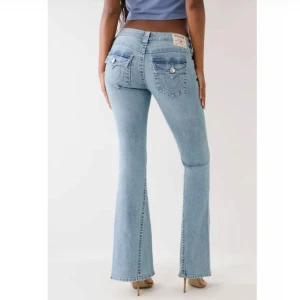 Lågmidjade bootcut jeans från True Religion - Säljer ett par supersnygga blå jeans från True Religion med låg midja och bootcut-passform. Jeansen är i storlek 26/32 och för referens är jag 169cm lång. Nypris: 1299
