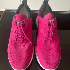  skinn sneakers med vit sula 38 från Blue on Blue  - Snygga rosa sneakers med vit sula och snörning. Skorna har en modern design med svart detalj vid hälen och är tillverkade i mocka. Perfekta för en trendig look. Mjuk mocka skinn, dyr inköp. Färgen är rosa ( cerise)som på bilden 