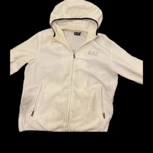 Vit vindjacka från Emporio Armani - Bra skick behövs bleckning. Passar L, baggi M
