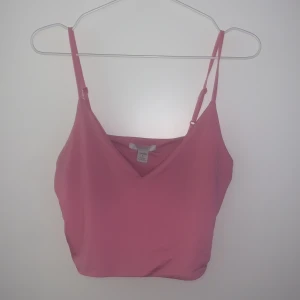Rosa linnetopp från New Yorker - Säljer en söt rosa linnetopp från New Yorker med justerbara axelband och v-ringning. Perfekt för varma sommardagar eller som ett lager under en kofta. Toppen är tillverkad i ett mjukt och bekvämt material. Den är i storlek L men sitter som S.