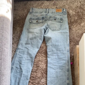 Ljusblå jeans med raka ben - Snygga ljusblå jeans med raka ben och klassisk femficksdesign. De har en knappgylf och bälteshällor för extra stil. Perfekta för en avslappnad look. Har ej används ofta och dem har ej några skador på jeansen.
