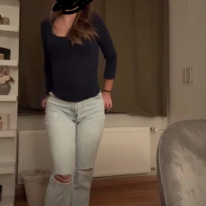 Ljusblå jeans från Bershka - Säljer ett par ljusblå jeans från Bershka i modellen ”90s wide”. De har en hög midja och en mer avslappnad passform med slitna detaljer vid knäna. Är i storlek XS (34) men passar mig med S (36). De är insydda längst ner för att ge en mer ”bootcut” look men det är inget som märks då det var gjort av en sömmerska.
