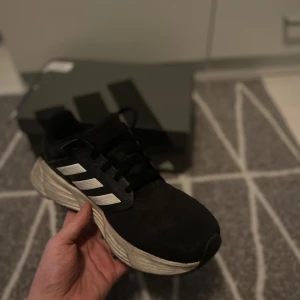 Svarta och vita adidas springskor - Svarta och vita adidas springskor  I storleken 41,33.  Vissa tecken på användning som Trådar och lite uttöja bitar (se bilder)   Finns ett litet hål på toppen   Perfect för våren, kontakta gärna vid frågor Postar inom 24h!                                                      (Kunde inte ha bilder på märkerna) !