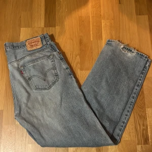 Levis 569 jeans i ljusblå denim - Säljer ett par Levis 569 jeans i ljusblå denim. Jeansen har slitna detaljer vid fållen för en trendig look. W36 L34