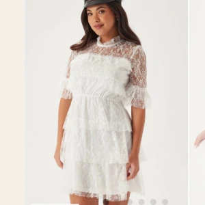 Student Vit spetsklänning - Säljer en elegant vit spetsklänning med trekvartsärm och volangdetaljer. Perfekt för studentens festligheter. Klänningen har en vacker, romantisk design med flera lager av spets.