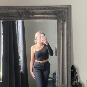 Svart ärmlös topp - Snygg svart topp, på den sidan där den är ärmlös är axelbandet i en guldig kedja