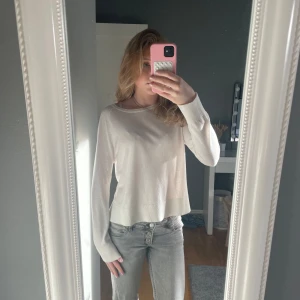 Vit långärmad tröja - Säljer en stilren vit långärmad tröja med ribbade muddar vid ärmslut och nederkant. Perfekt för en enkel och klassisk look. Passar bra till jeans eller kjol. Tunn stickad och väldigt fin. Bra kvalité och väldigt bra skick då den inte är använd så mycket.
