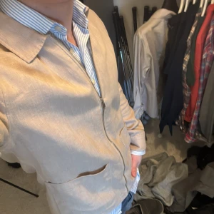 Beige jacka med dragkedja - Säljer en stilren beige jacka med dragkedja. Jackan har en klassisk krage och två praktiska fickor framtill. Perfekt för en avslappnad look. Overshirten är i 100% linne. Nypris på denna är runt 2000kr. Skriv vid funderingar!🙌